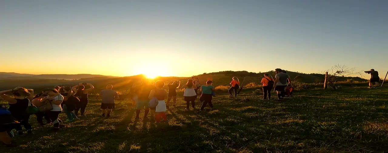 A turma reunida no alto assistindo o sol estourar dourado no horizonte
