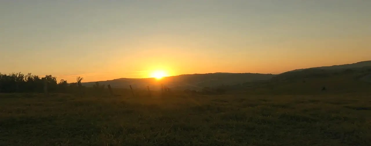 Pôr do sol laranja incendiando o horizonte no fim do dia de aventura